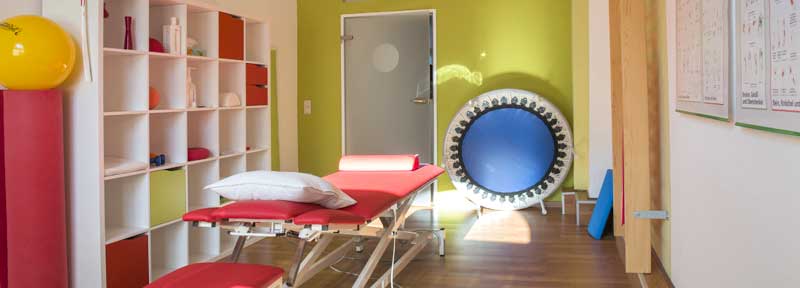 Behandlungsraum mit Liege, Trampolin, Physioball und anderen Geräten