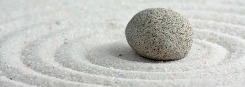 Ein runder Kieselstein, der in Sandkreisen liegt